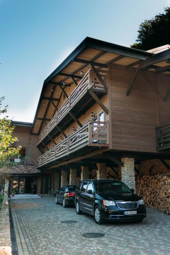 a car parked in front of a building with a balcony at BRB Park Hotel in Vizhenka