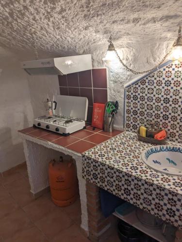 a kitchen with a stove and a counter top at Cuevas Barrio Las Santas in Huéscar