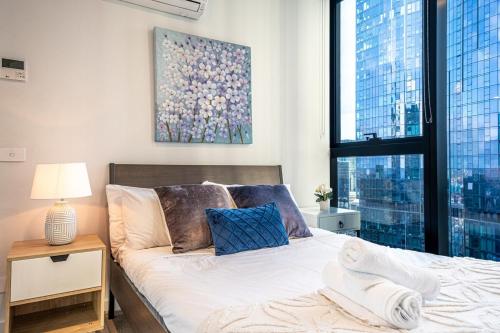 - une chambre avec un lit et une grande fenêtre dans l'établissement Spectacular High Level 2br Cbdpoolgymwi-fi, à Melbourne