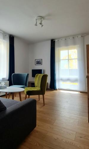 a living room with a couch and chairs and a table at Apartamenty Dębowa 3 in Polanica-Zdrój