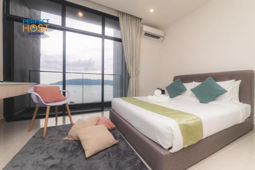 a bedroom with a bed and a desk and a window at The Shore Kota Kinabalu By Perfect Host Borneo in Kota Kinabalu