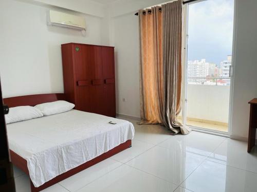 a bedroom with a bed and a large window at Rideway wellawatte in Colombo