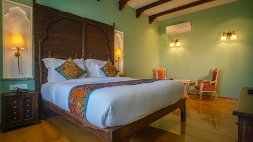a bedroom with a large bed and a table at Khamma Ghani A Boutique Hotel in Udaipur