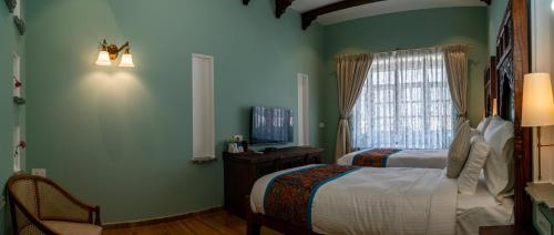 a bedroom with a bed and a television in it at Khamma Ghani A Boutique Hotel in Udaipur
