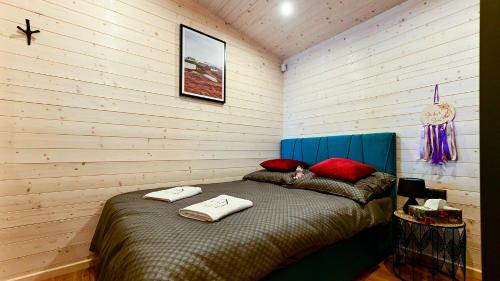 Un dormitorio con una cama con almohadas rojas. en Lawendowe Domki Latoszyn-Zdrój Domek Hygge, en Latoszyn