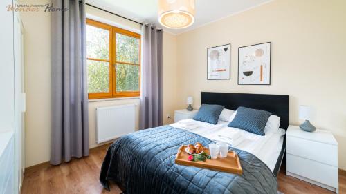 a bedroom with a bed with a tray of food on it at Wonder Home - Domki górskie z kominkami, bezpłatnym parkingiem i placem zabaw na terenie kompleksu in Karpacz