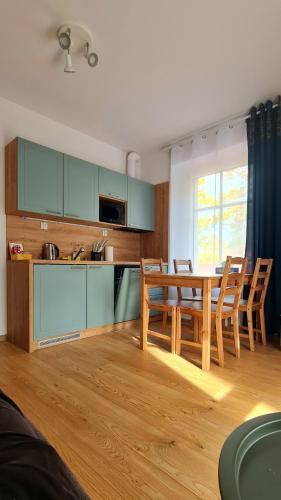a kitchen with a table and chairs in a room at Apartamenty Dębowa 3 in Polanica-Zdrój