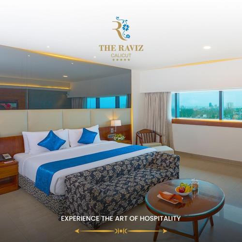 a hotel room with a bed and a table at The Raviz Calicut in Kozhikode