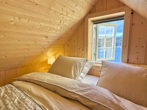 a bed in a wooden room with a window at Boathouse in city centre with harbour view in Tórshavn