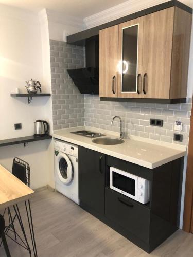 a kitchen with a sink and a washing machine at Opus Apart Hotel in Kusadası