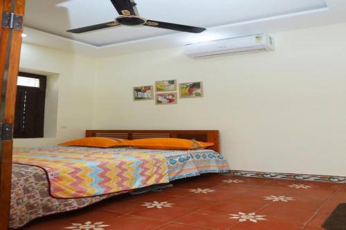 - une chambre avec un lit et un ventilateur de plafond dans l'établissement Heritage home with 3 bed/3 bath with kitchen in a residential neighborhood., à Madurai