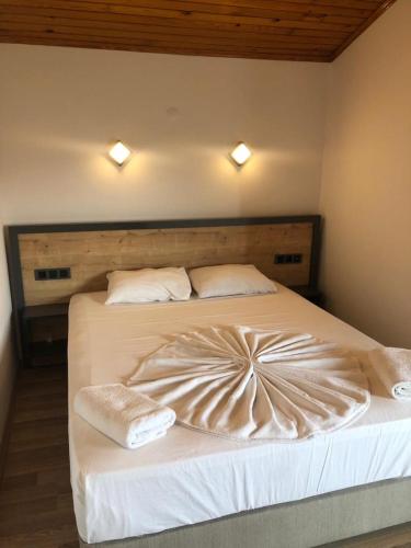 a bedroom with a large bed with white sheets and pillows at Opus Apart Hotel in Kusadası