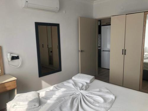 a white bed in a room with a mirror at Opus Apart Hotel in Kusadası