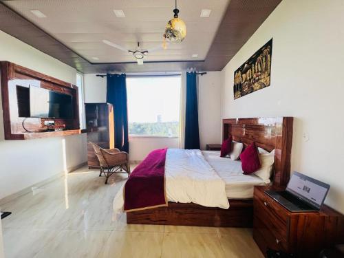 Un dormitorio con una cama grande y una ventana en GREEN DANDI HOMESTAY en Rishīkesh