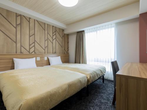 um quarto de hotel com uma cama e uma janela em Kyoto Plaza Hotel Kintetsu Jujo em Quioto