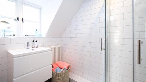 biała łazienka z umywalką i prysznicem w obiekcie Joe's Cottage w mieście Bridgnorth