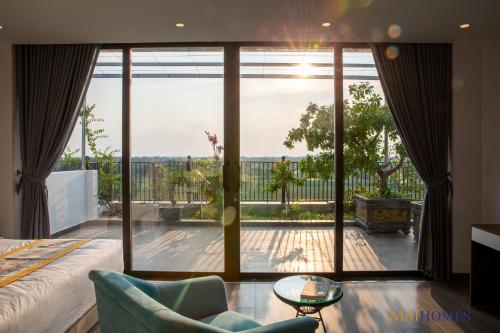 a bedroom with a large glass door with a view of a patio at Maihomes Hotel Vĩnh Yên Vĩnh Phúc in Yen