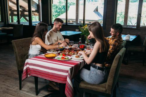 a group of people sitting around a table in a restaurant at BRB Park Hotel in Vizhenka