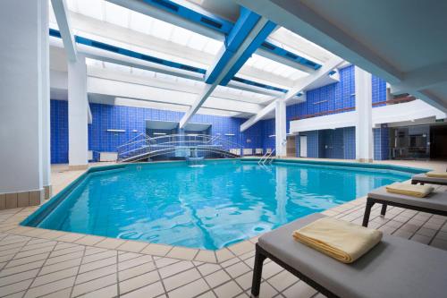 a large swimming pool with blue water in a building at Hotel Admiral - Liburnia in Opatija