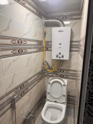 a bathroom with a toilet and a box on the wall at Sovet Hostel in Baku