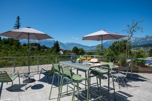 a table and chairs with umbrellas on a patio at Livingreen Residences in Feldkirch