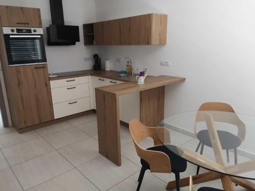 a kitchen with a glass table and two chairs at Apartments Ole in Tolmin
