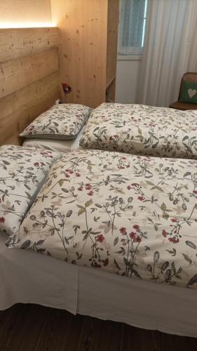 duas camas com um edredão com flores em Mara em Levico Terme