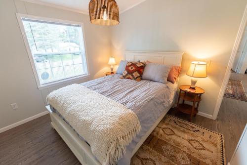 um quarto com uma cama com 2 candeeiros e uma janela em The Castle: Lake Views, Comfort, Nature, Decor em Cambridge Springs