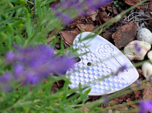 a spoon sitting on the ground next to some flowers at Major Residence in Tihany