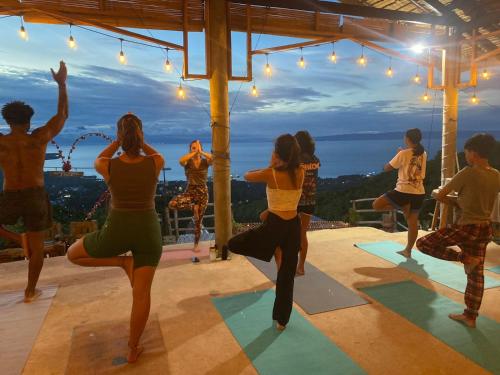 grupa ludzi uprawiających jogę na zajęciach jogi w obiekcie Thornton's Sea View Cafe & Guesthouse w mieście Siquijor