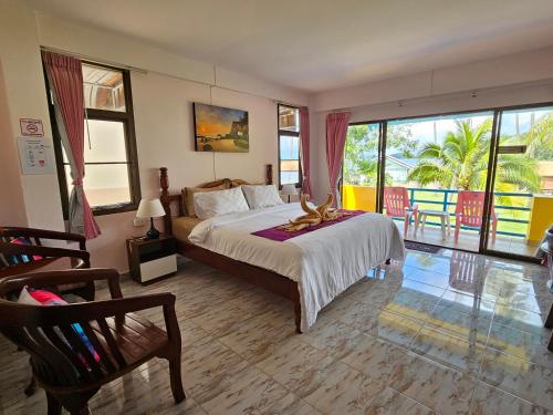 a bedroom with a large bed and a balcony at Lanta MP Place in Ko Lanta