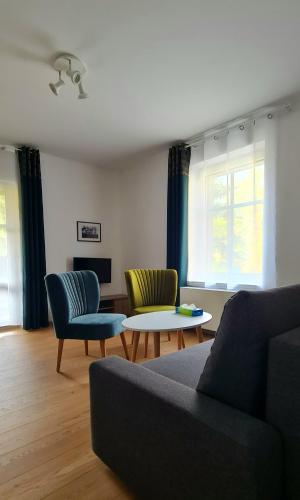 a living room with two chairs and a couch and a table at Apartamenty Dębowa 3 in Polanica-Zdrój