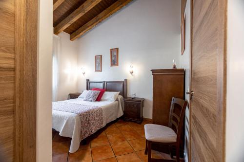 a small bedroom with a bed and a chair at Apartamentos El Pedrayu in Onís