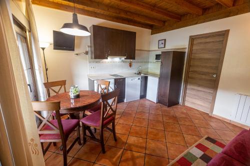 a kitchen with a table and chairs in a room at Apartamentos El Pedrayu in Onís
