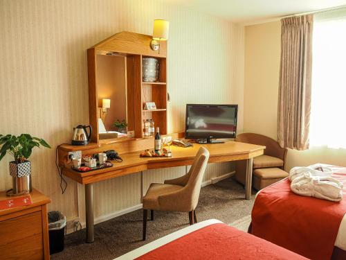 a hotel room with a desk with a computer at Future Inn Cardiff Bay in Cardiff