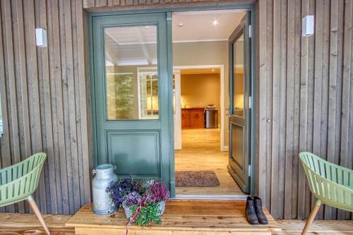 a green door in a house with two chairs at Hof Wölper Raven in Soderstorf