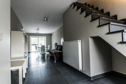 a living room with a staircase and a couch at Vakantiewoningen De Jud in Maasmechelen