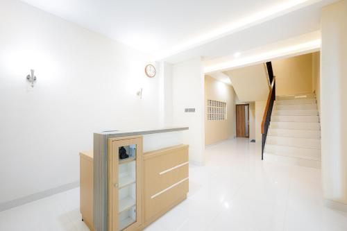 a staircase in a house with white walls and white floors at Urbanview Hotel Syariah The Ragunan Residence in Jakarta