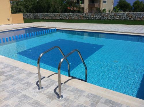 a swimming pool with a stairway leading into a swimming pool at Gerona Mare Apartments in Gerani Chanion