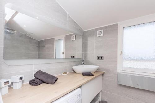 une salle de bain blanche avec un lavabo et un miroir dans l'établissement Le Mas de la mer appartement standing piscine climatisation - Sanary, à Sanary-sur-Mer