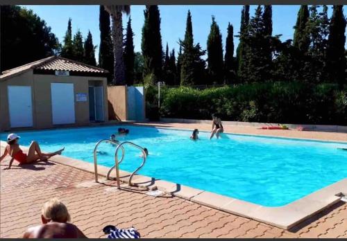 un groupe de personnes dans une piscine dans l'établissement Le Mas de la mer appartement standing piscine climatisation - Sanary, à Sanary-sur-Mer
