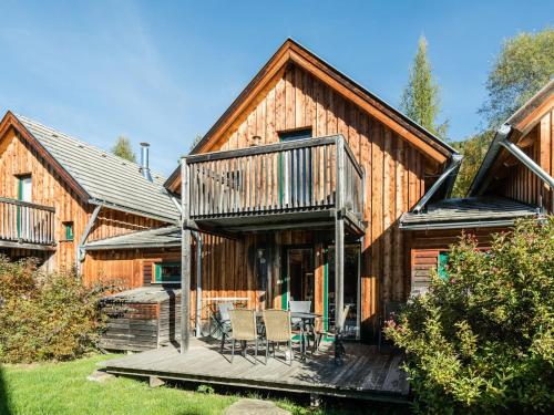 ザンクト・ローレンツェン・オプ・ムーラウにあるSpacious Chalet near Ski Area in Sankt Georgen ob Murauの木造家屋(デッキ、椅子付)