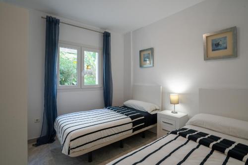 2 camas en una habitación con ventana en Beach Front apartment in Puerto Banus en Marbella
