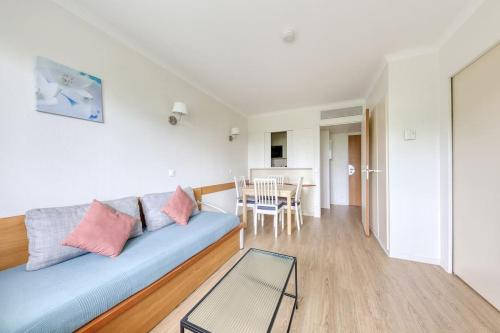 un salon avec un canapé bleu et une table dans l'établissement 7 min walk to La Défense modern flat in aparthotel, à Courbevoie