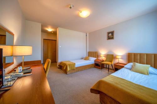 a hotel room with a bedroom with a bed and a desk at Hotel Gromada Radom Centrum in Radom