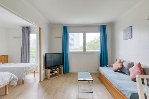un salon avec un canapé et une télévision dans l'établissement 7 min walk to La Défense modern flat in aparthotel, à Courbevoie