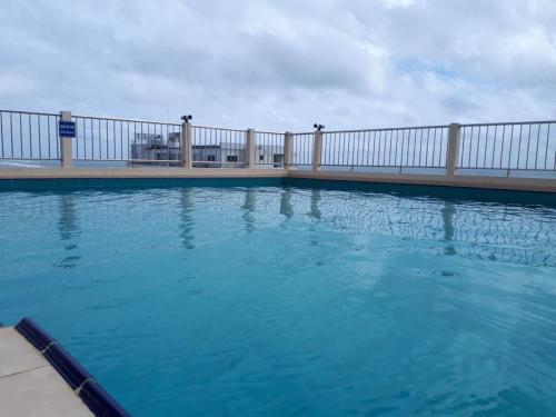 a swimming pool with a fence and blue water at Rideway wellawatte in Colombo