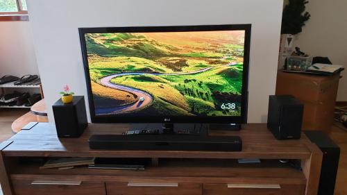 a flat screen tv on a wooden stand with speakers at Clayton Living Town House at Monash Doorstep in Clayton North