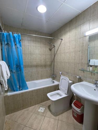 a bathroom with a toilet and a tub and a sink at Marbella Grand Holiday Homes - Al Nahda 1 in Dubai