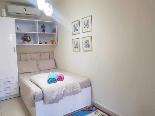a small bedroom with a bed with two hats on it at وحده فندقية باطلالة على حمام السباحة فى فيرندا سهل حشيش ريزورت in Hurghada